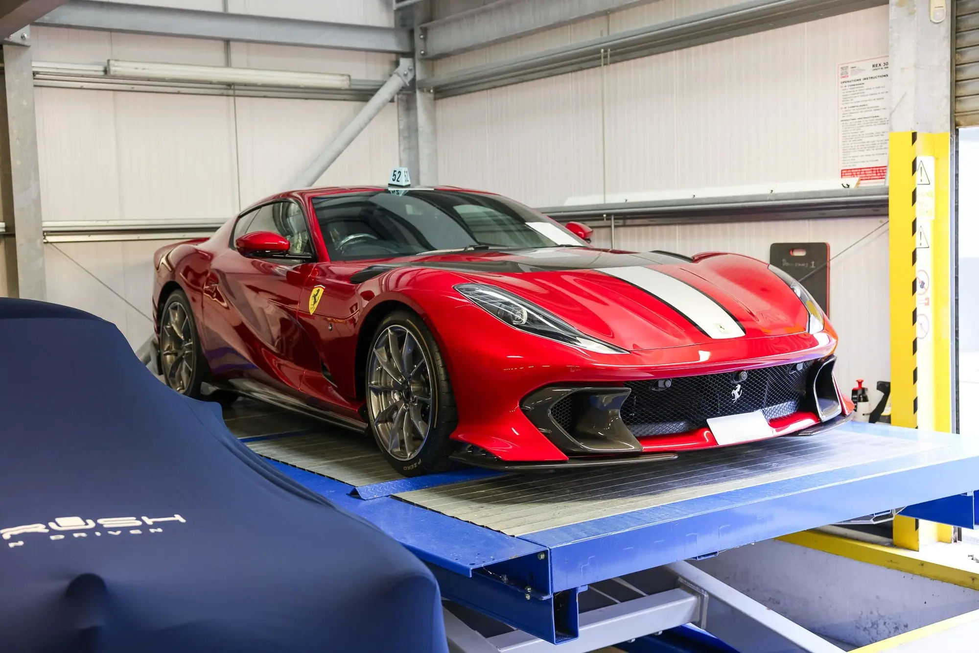 A Ferrari on a lift ready for shipping