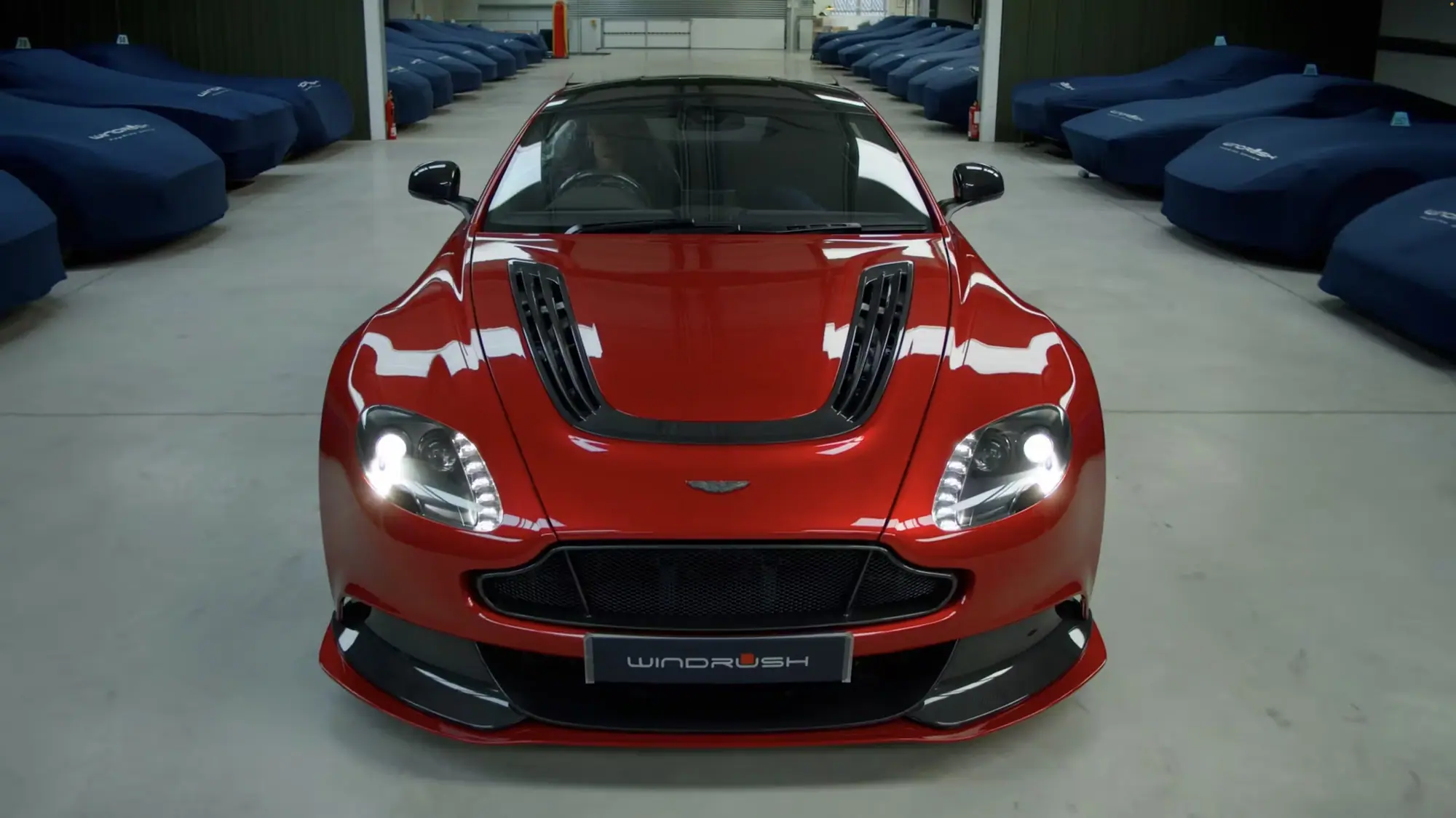 An Aston Martin Vanquish facing the camera, rows of covered cars behind it in the London vault