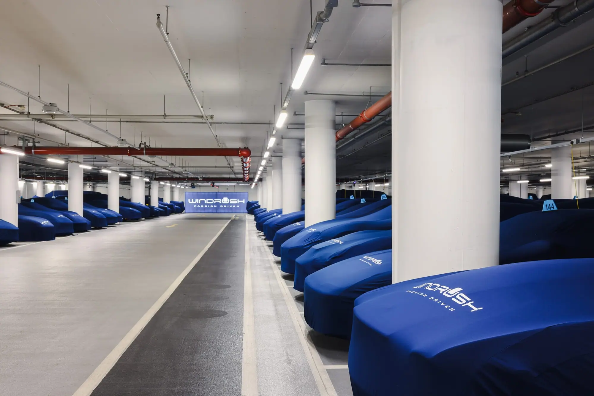 A long aisle of covered cars