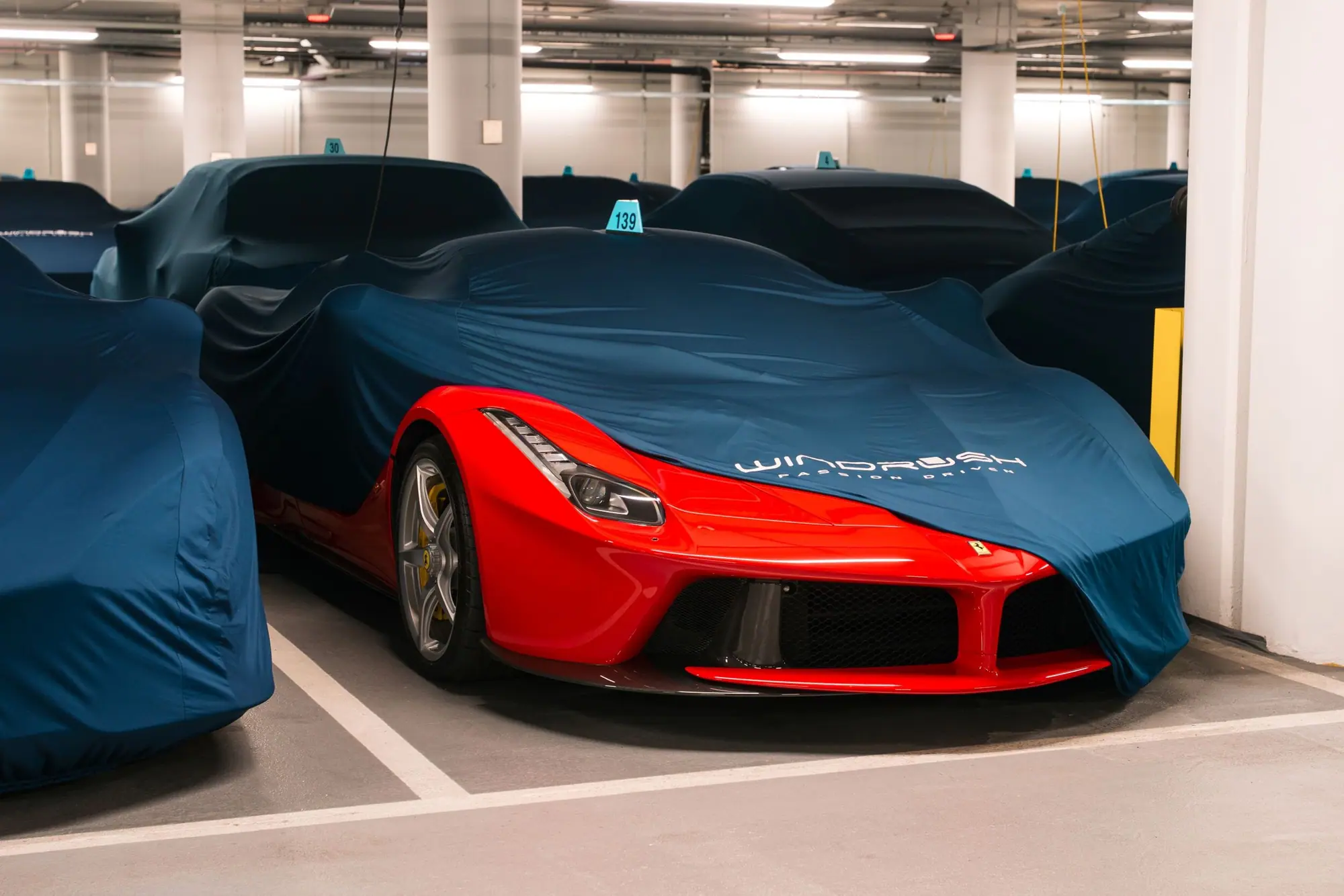 A LaFerrari half under its navy cover